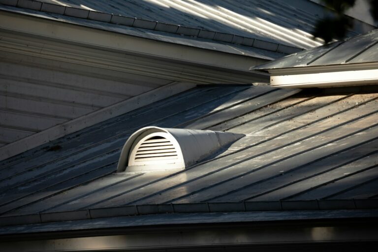 An attic with clean insulation, visible rafter baffles, and daylight entering through soffit ventilation channels.